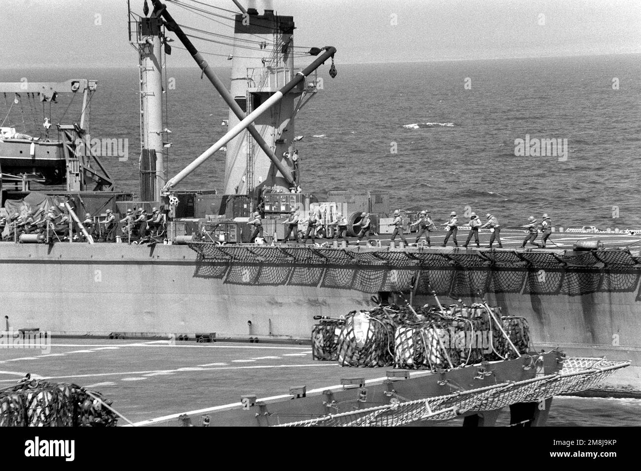 Line handlers pull in a shot line on the tank landing ship USS CAYUGA