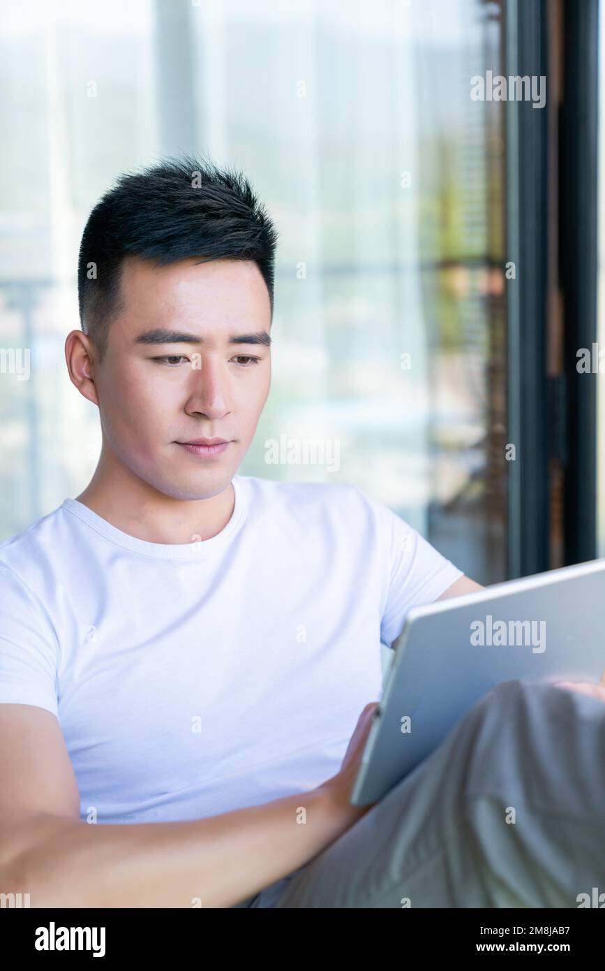 Young Man Using Tablet The young man use tablets Stock Photo - Alamy