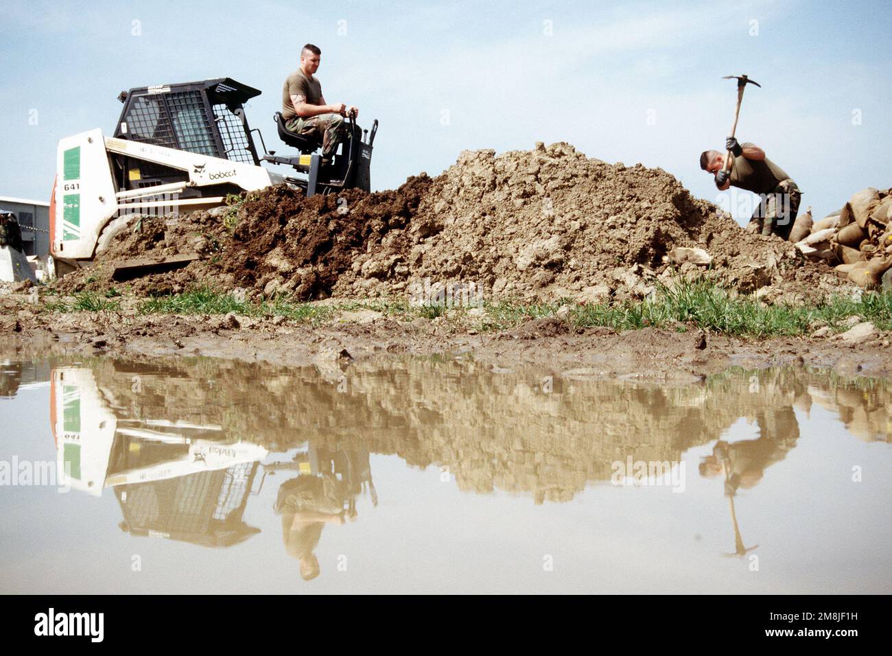 A Seabee operates an earthmover as another Seabee uses a pick axe at one of several sites being worked on at Camp Pleso.(Exact date unknown). Subject Operation/Series: PROVIDE PROMISE Base: Zagreb Country: Croatia (CRO) Stock Photo