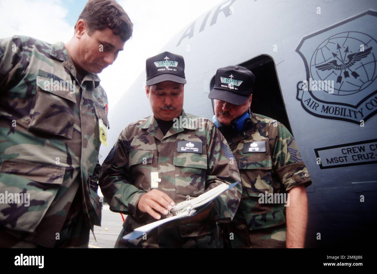 MSG Ed Cruz-Segarra (center), crew chief, and MSG Jim Baker (right), point out to RODEO 94 pre-flight inspection judge SMS Joe Mahnken (left) that the descrepancy he discovered is already annotated in the aircraft maintenance log. Subject Operation/Series: RODEO 94 Base: Mcchord Air Force Base State: Washington (WA) Country: United States Of America (USA) Stock Photo