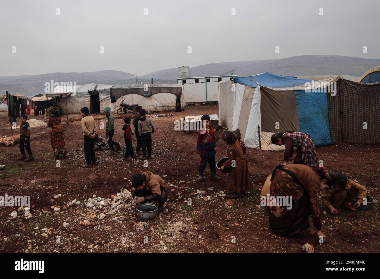 Idlib, Syria. 14th Jan, 2023. Children collect charcoal for heating in