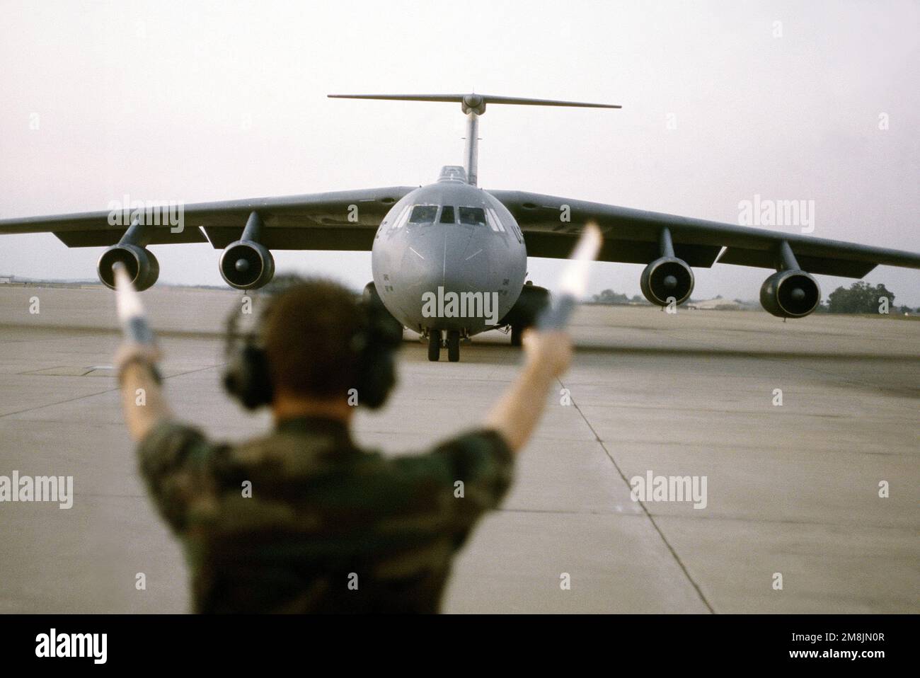 SRA Michael Robinson from the 436th Tactical Airlift Control Element, (TALCE) Aircraft Generation Squadron (AGS) marshals an Air Mobility Command's C-141 Starlifter into position at Kigali Airport. Subject Operation/Series: SUPPORT HOPE Base: Kigali Country: Rwanda (RWA) Stock Photo