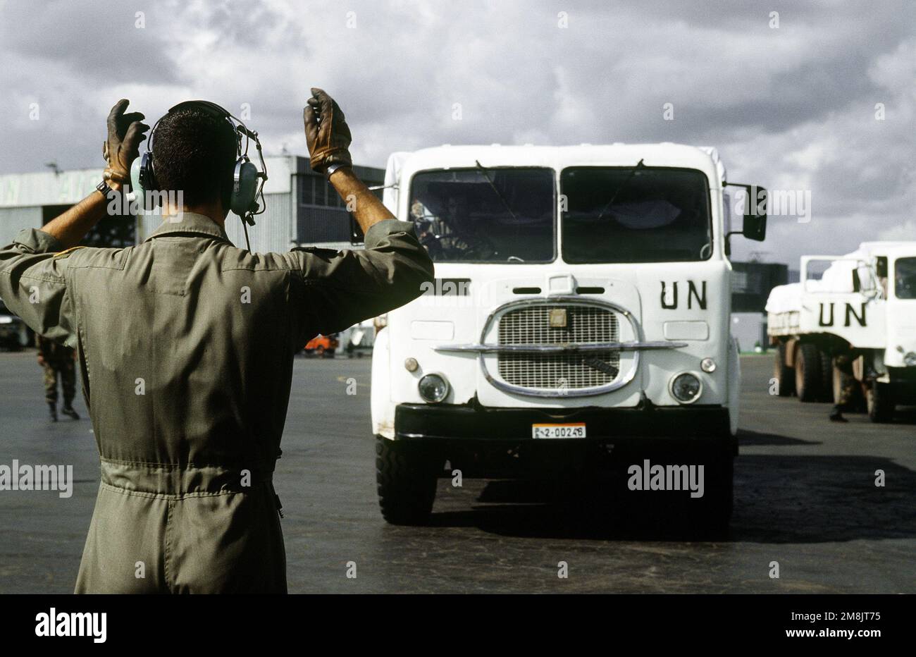 An Air Force loadmaster marshals a large United Nations truck into position on the ramp at Addis Ababa International Airport. The truck is part of equipment destined for use in the multinational policing effort for the refugees of the Rwandan civil war. Subject Operation/Series: SUPPORT HOPE Base: Addis Ababa Country: Ethiopia (ETH) Stock Photo