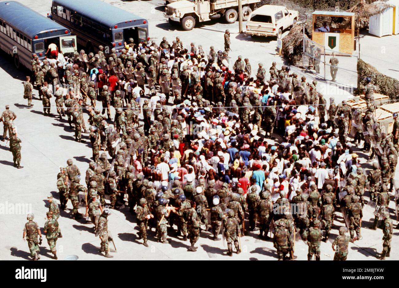 Disruptive Haitians are loaded into buses by MPs in riot gear from the ...