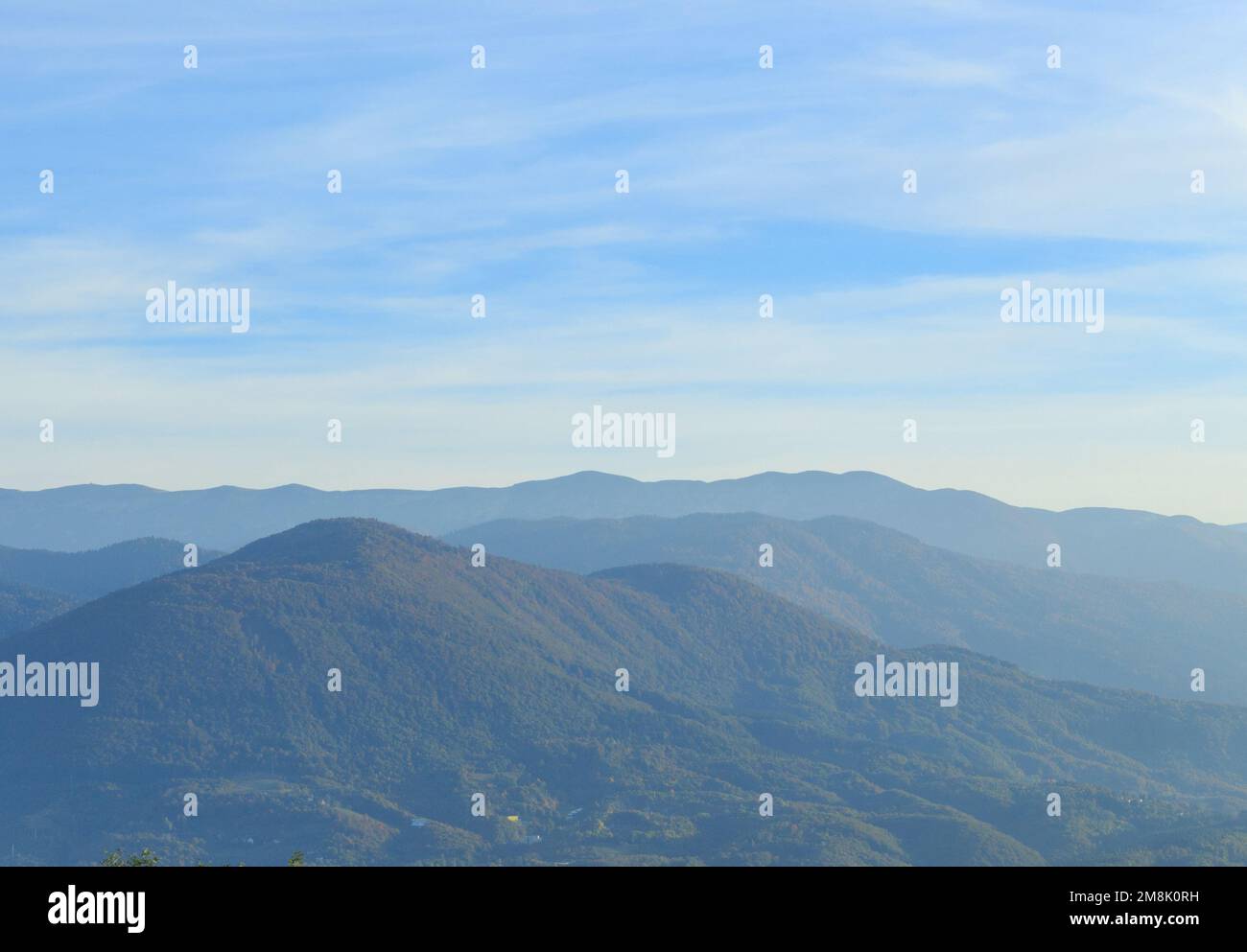 The hills with green lush trees against a blue sky in Sarajevo Stock Photo