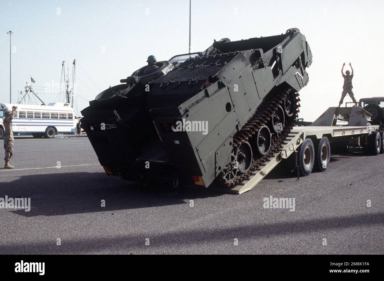 Soldiers from the US Army Material Command, Logistics Support Element, direct an M9 Armored Combat Earthmover on to a trailer to be transported from the 15th Brigade Camp to the Port of Kuwait where they will be loaded onto a ship. Subject Operation/Series: VIGILANT WARRIOR Base: Kuwait City Country: Kuwait (KWT) Stock Photo