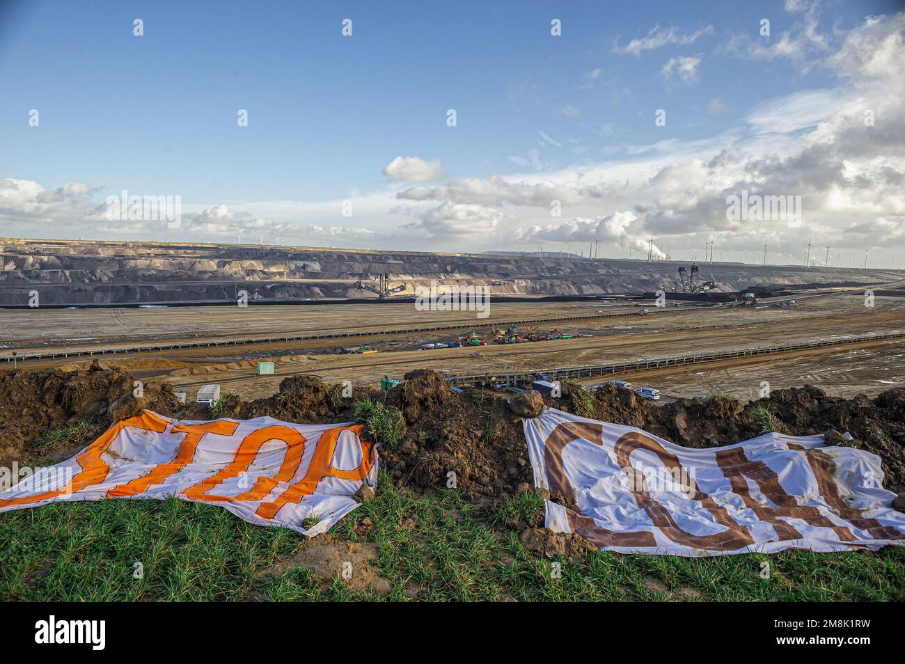 View of Open-Pit mine and two signs, one says ëSTOPí and the other states ëCOALí during the evection and security clamp-down. The German town of Lutzerath, not too far from the Dutch border, has had a makeshift village occupied by climate activists for the better part of two years. All came to an abrupt end this week, as police arrived in mass and totaling 1000 strong, to dismantle, arrest and evict the village occupiers from the settlement they refer to as ‘Utopia'. Checkpoints manned all entry points leading to and from the village. The accommodation consists of makeshift homes, built from d Stock Photo