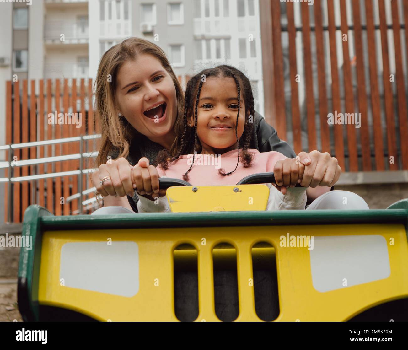 A happy mother wit her daughter on a ride in a playground Stock Photo ...