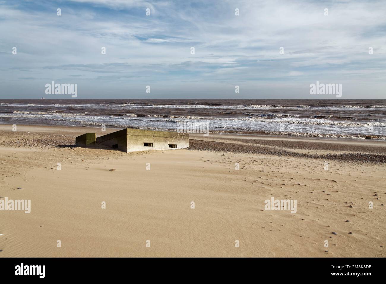 WW2 pill box has fallen down onto the beach caused by coastal erosion. Stock Photo