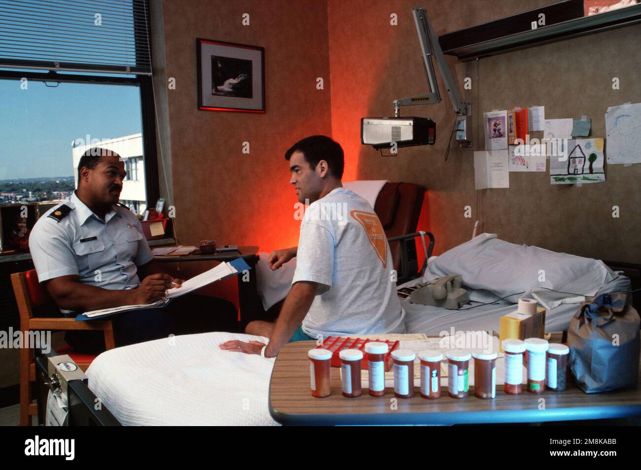 USAF Major Wilson, reviews health care options under the new military health care program 'TriCare' with his patient. From AIRMAN Magazine's May 1995 issue article 'Healthier People'. Country: Unknown Stock Photo