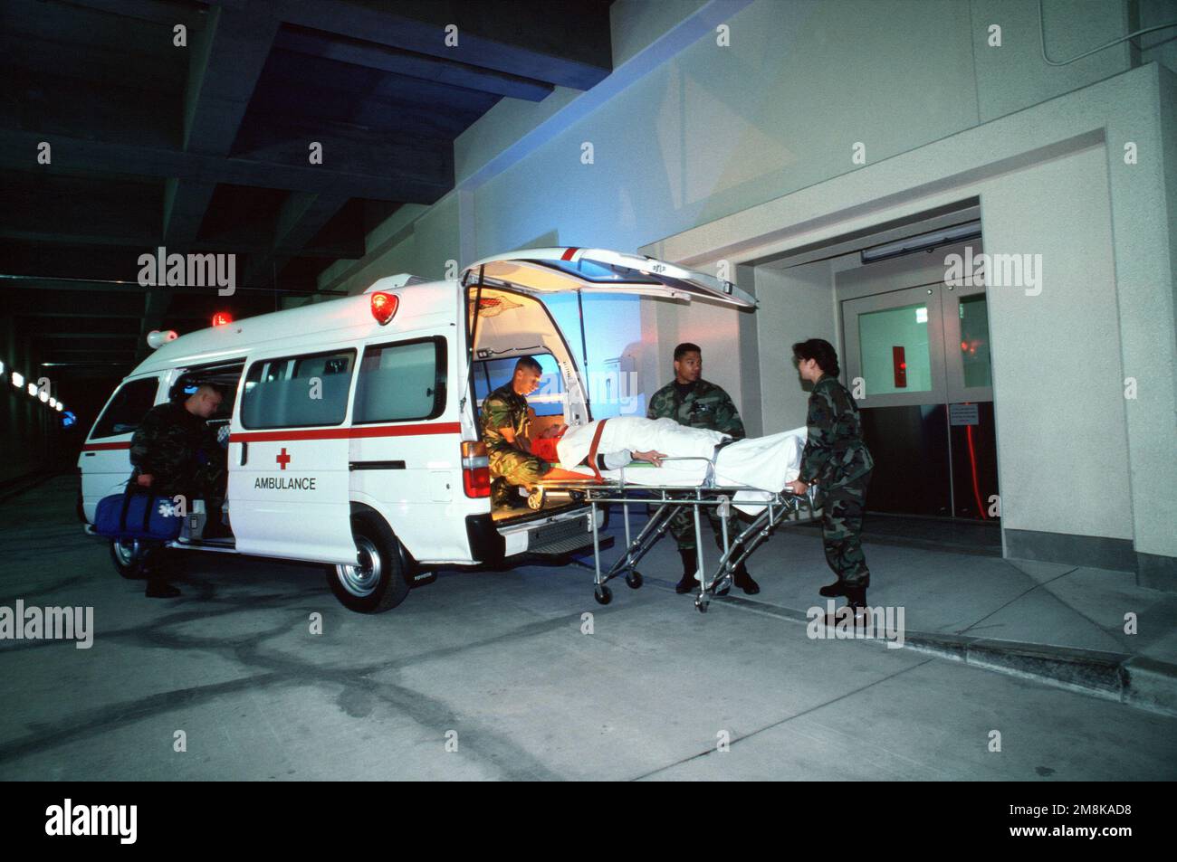An Emergency Medical Ambulance team off loads a critical patient at the hospital emergency entrance, 'TriCare' the new military health care program, will provide more health care choices and access to affordable and high-quality care. From AIRMAN Magazine's May 1995 issue article 'Healthier People'. Country: Republic Of Korea (KOR) Stock Photo
