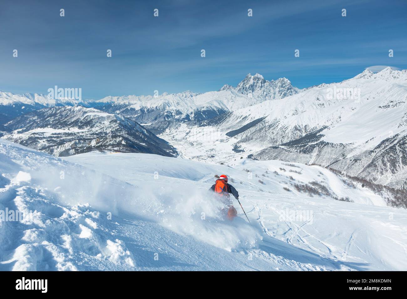 A skier is freeriding against the background of the peaks of Mount Ushba, the Great Caucasian Range in winter, Stock Photo