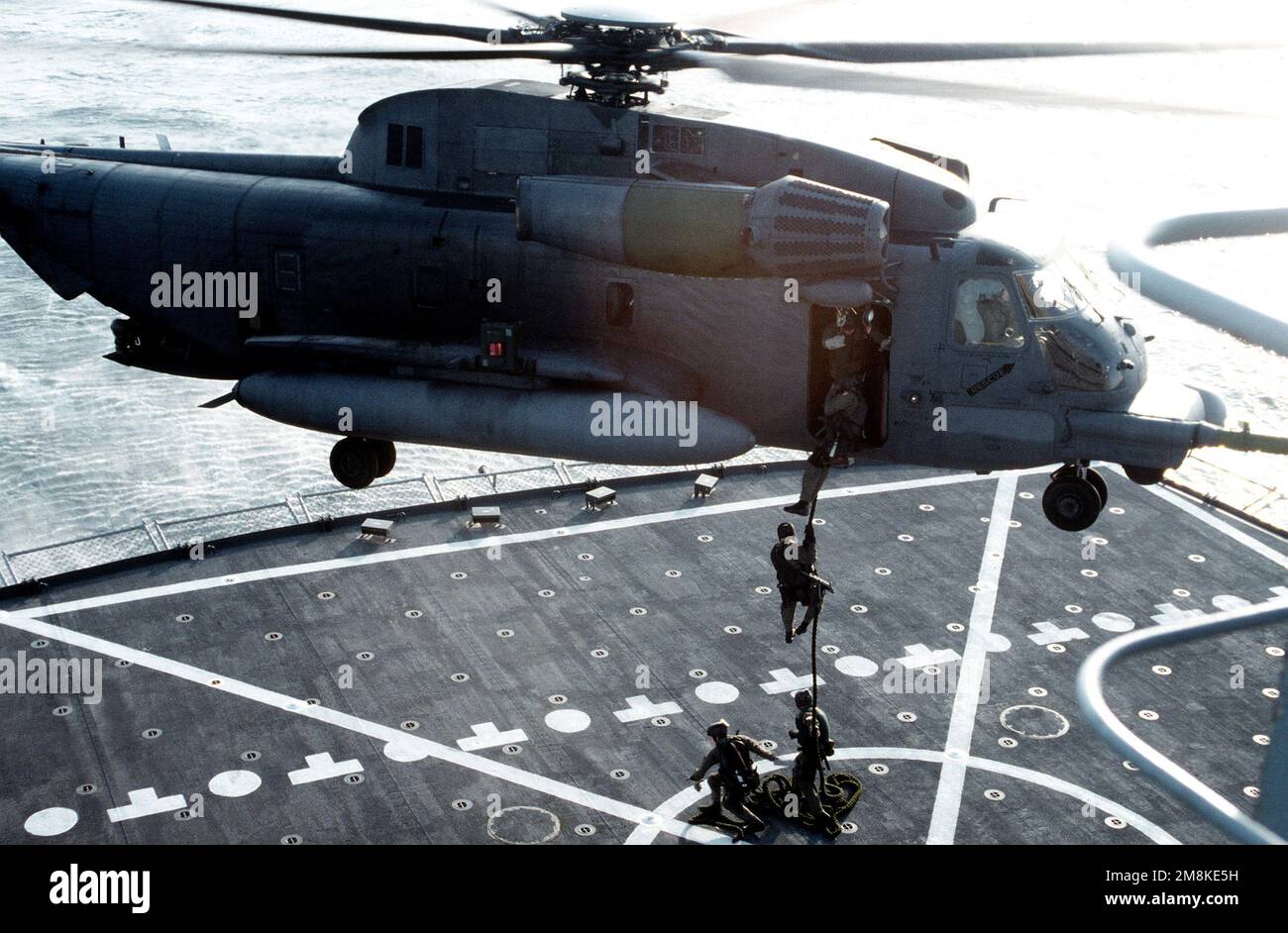 US Navy SEALs fast rope from a US Air Force Special Operations MH-53 Pave Low helicopter to the deck of the USNS LEROY GRUMMAN during a search and seizure exercise. (Exact date shot unknown). Country: Adriatic Sea Stock Photo