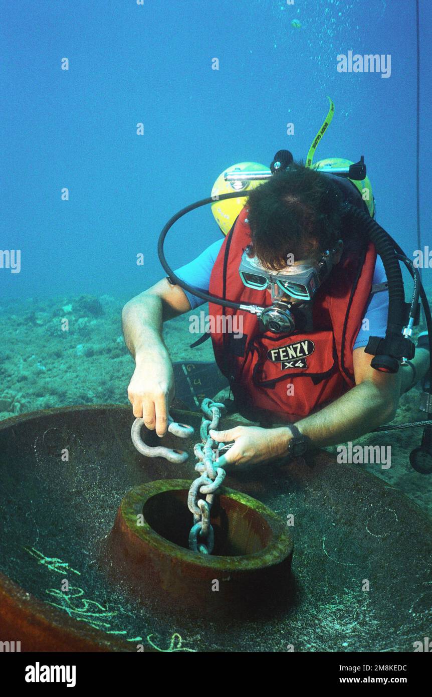 Utilityman Third Class (UT3) Gilbert Negrette, a member of Underwater Construction Team Two (UCT-2), places a shackle on a mooring anchor during cable system repairs at the Pacific Missile Range Facility off Kauai, Hawaii. Country: Pacific Ocean (POC) Stock Photo