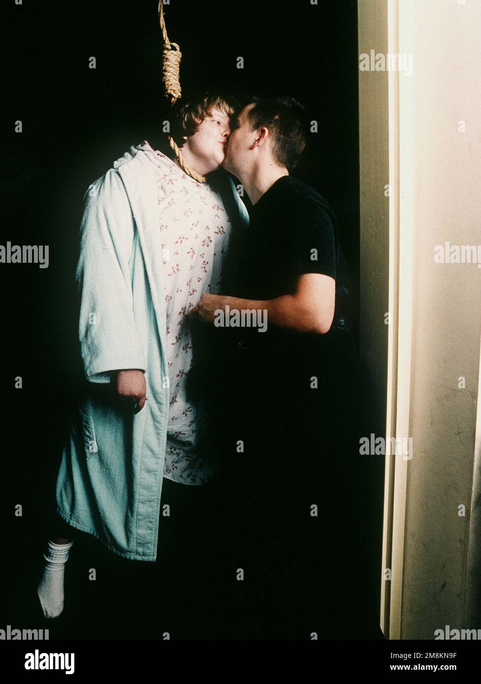 Military Photographer of the Year Winner 1996 Title: You Keep Me Hanging On Category: Portfolio Brief Description: A man and a woman, with a noose around her neck, stand in a doorway exchanging a gentle kiss. Exact Date Shot Unknown. Country: Unknown Stock Photo