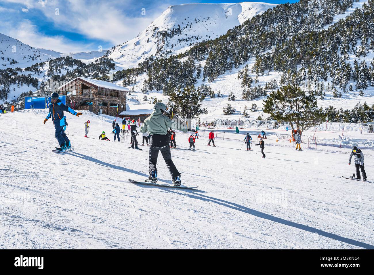 Instructor or trainer teaching how to snowboard in El Tarter green area. Winter ski holidays in Andorra, Grandvalira, Pyrenees Mountains Stock Photo