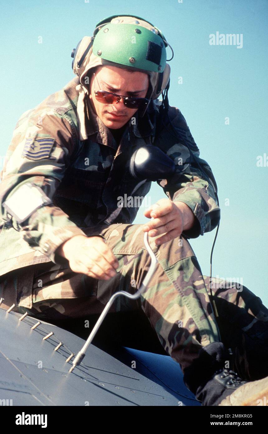 Technical Sergeant Ron Kemp, 14th Fighter Squadron, Misawa, Japan, unscrews the access panel to the Emergency Power Unit in an F-16 Falcon so that he can perform maintenance on the unit. Exact Date Shot Unknown. Subject Operation/Series: NORTHERN EDGE 96 Base: Eielson Air Force Base State: Alaska (AK) Country: United States Of America (USA) Stock Photo