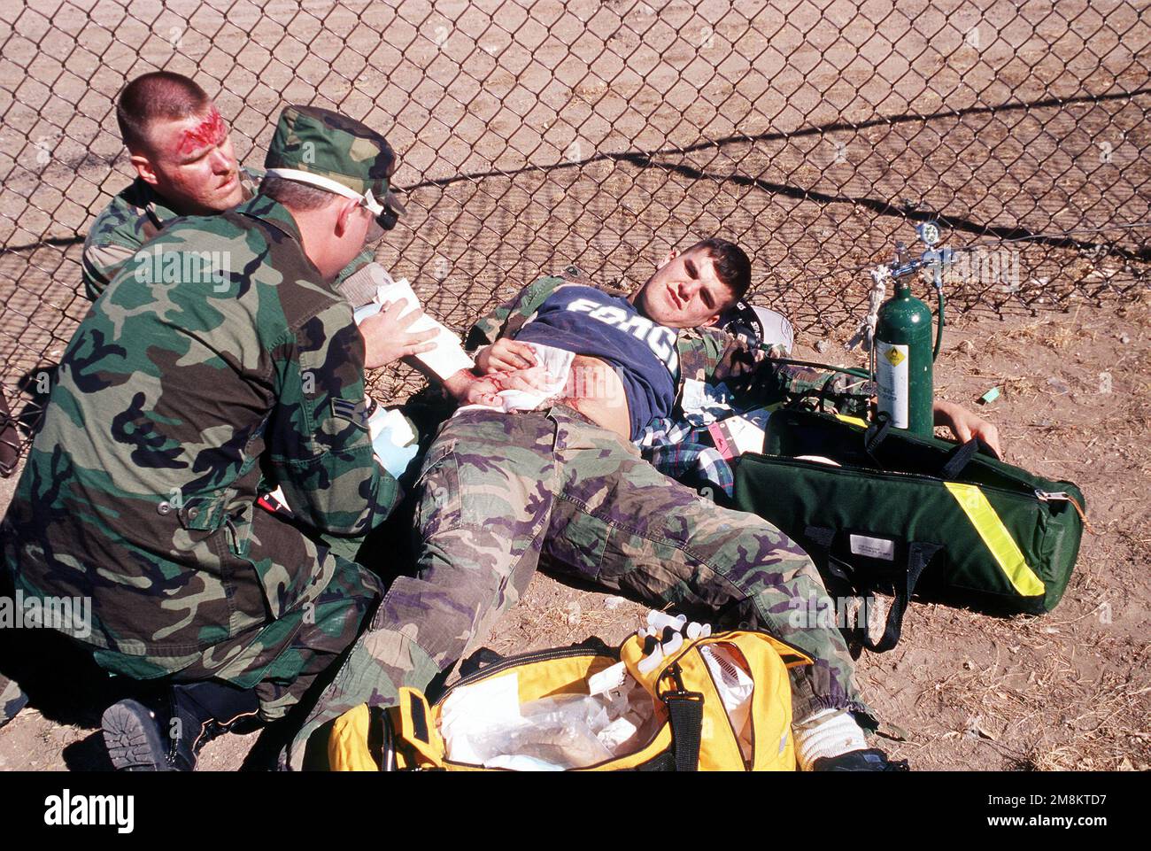 Simulated C-130 aircraft crash casualty, Paul Shields of the 21st LSS/LGTTS, suffering from a simulated abdominal wound is treated by AIRMAN 1ST Class Kevin Bradley of the 21st Space Wing's Medical Group. Emergency personnel from the Fire Department, Search & Recovery, Bioenvironmental, Mobil Command and Control and the Medical group all responded to this part of the 21st Space Wing's Operational Readiness Inspection that was conducted at Cheyenne Mountain Air Station and Peterson AFB, Colo., 13 to 17 February 1996. The Inspector General's Team tested their ability to respond to battle conditi Stock Photo