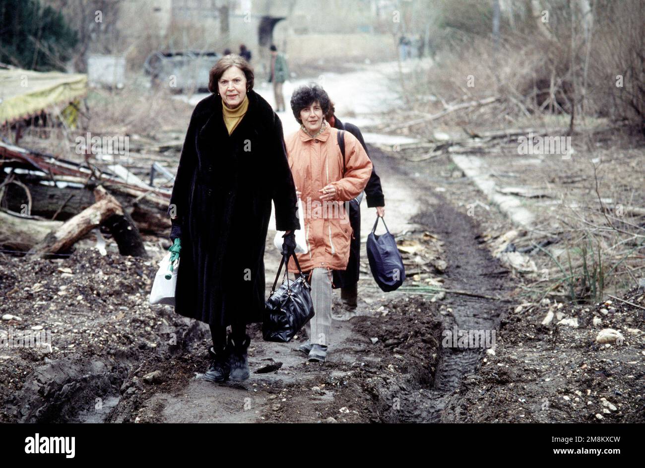 Muslim women make their way through the mud as they carry their belongings to their new apartments in this Sarajevo suburb called Grbavica. The apartments and houses once occupied by Bosnian Serbs are the last group to be turned over to the Muslims as required by the recent Dayton Peace accord which produced a cease fire and permanent borders. Subject Operation/Series: JOINT ENDEAVOR Base: Grbavica State: Sarajevo Country: Bosnia And/I Herzegovina (BIH) Stock Photo