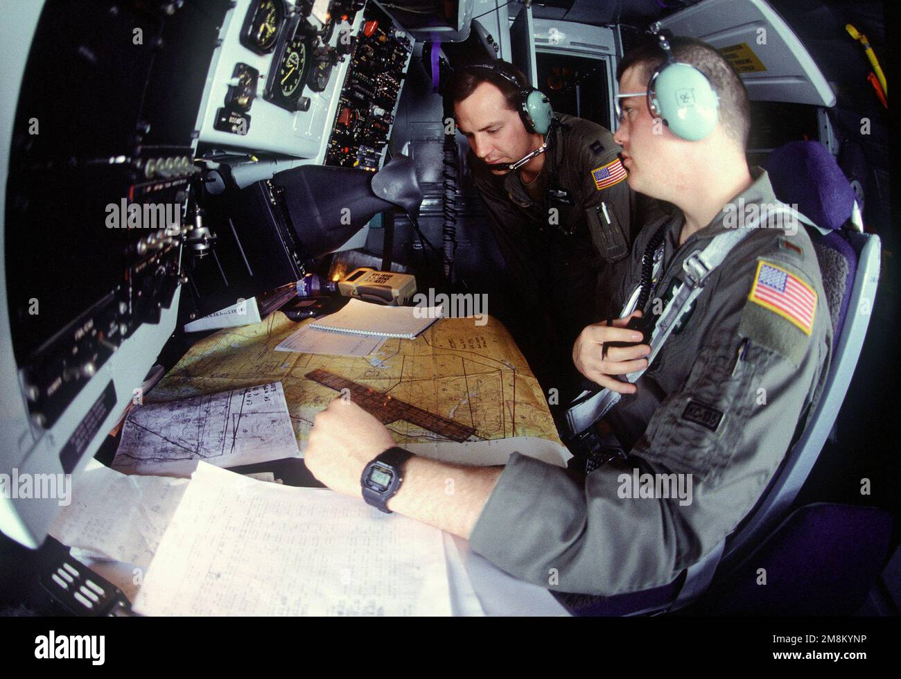 Navigators, 2nd Lieutenant Mathew C. Brennan (Right, Hometown: Baltimore, Maryland) and Captain Rod F. Cosgrove (Left, Hometown: Colorado Springs, Colorado) from the 96th Air Refueling Squadron, Fairchild Air Force Base, Washington check the navigation maps during a mission in a KC-135 aircraft over Jordan in support of the Air Power Expeditionary Force. An ancillary mission of the Force is to assist US Air Force and other multinational forces operating in Saudi Arabia and other nearby countries patrol the no-fly zone over southern Iraq. Subject Operation/Series: AIR POWER EXPEDITIONARY FORCE Stock Photo