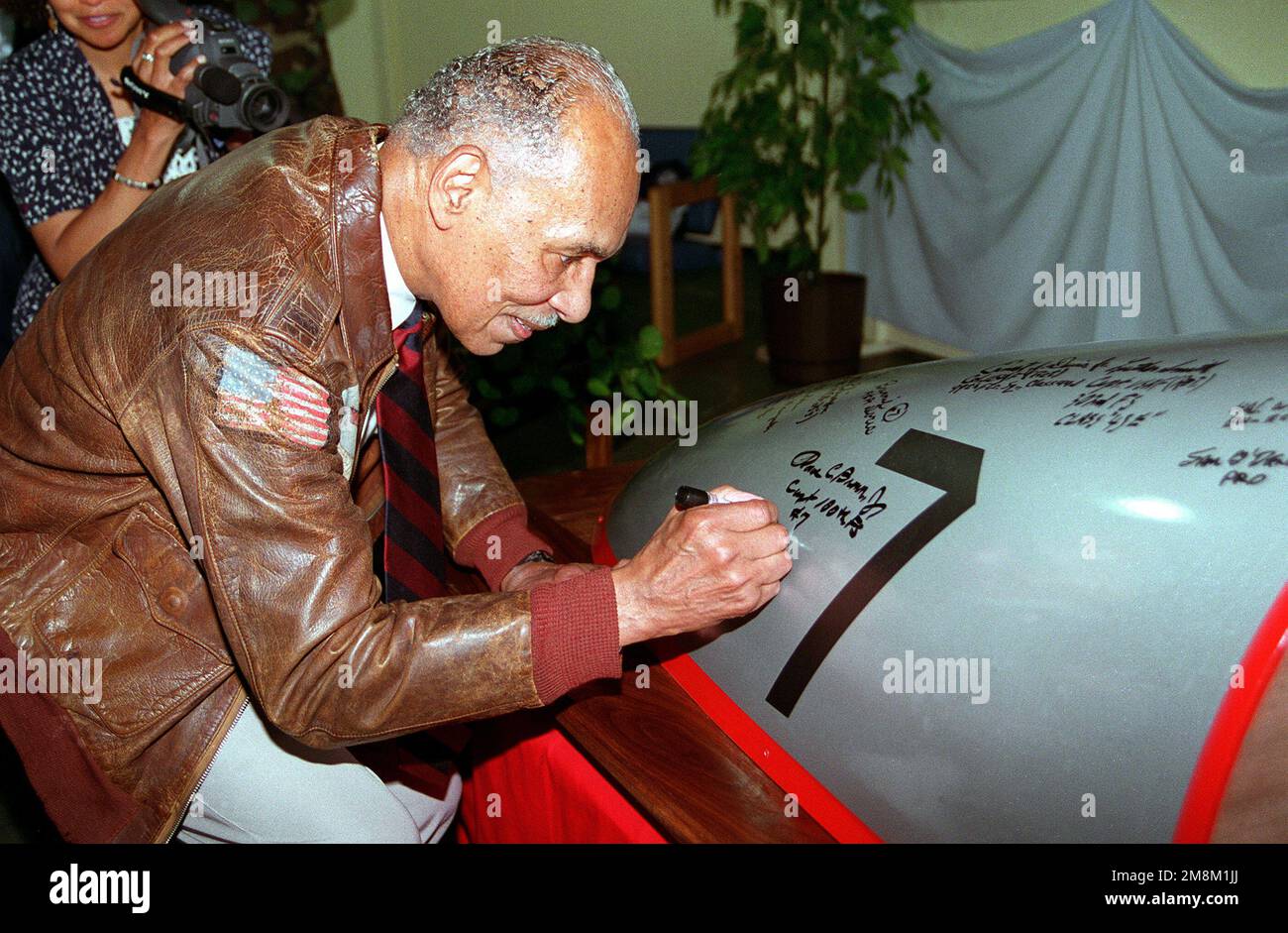 Dr. Roscoe C. Brown, Jr., member Tuskegee Airmen, signs a canopy modeled  after his P51 D Mustang during a reception following unveiling ceremonies.  Base: Dover Air Force Base State: Delaware (DE) Country