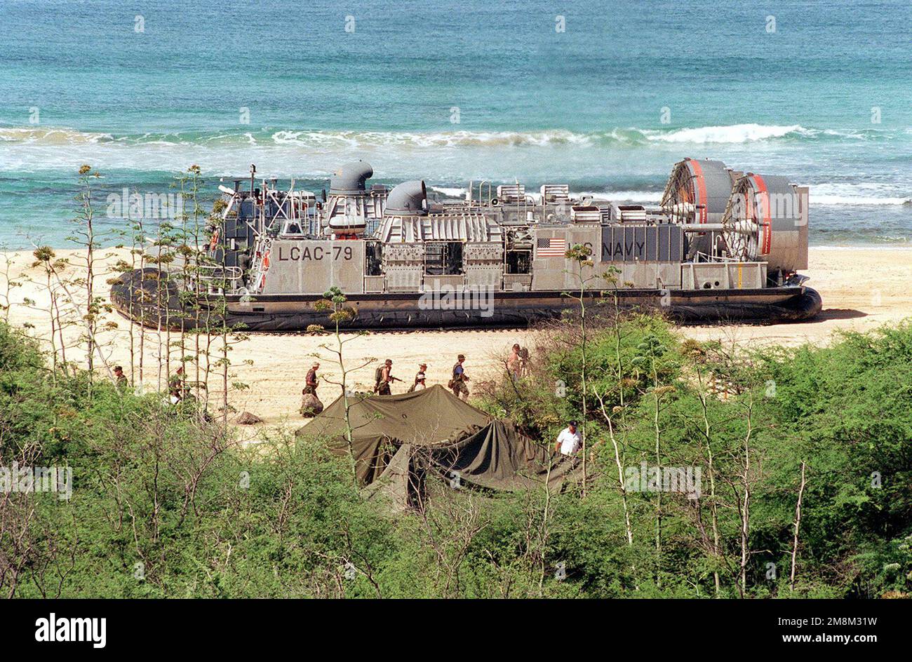 A starboard side medium shot, as seen from atop a hill, of the US Navy