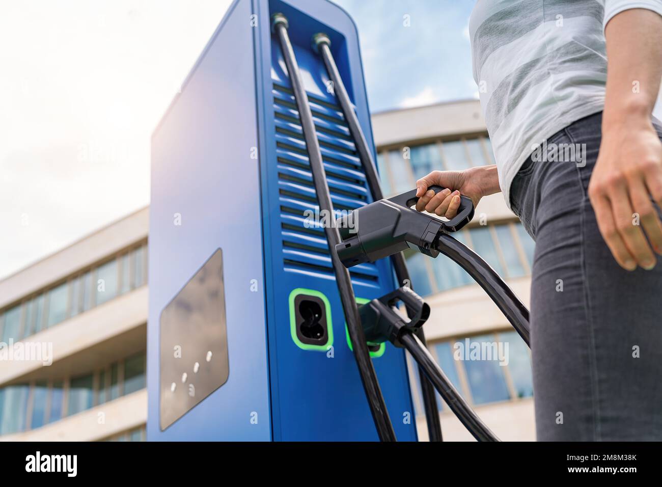 woman insert a DC - CCS type 2 EV charging connector at EV charging ...
