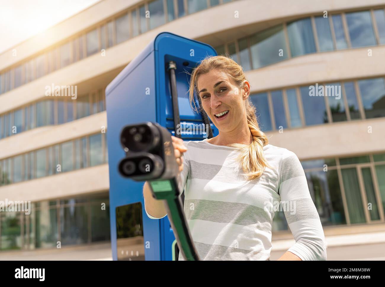 woman holding a DC CCS2 EV charging connector on a Hypercharger or ...
