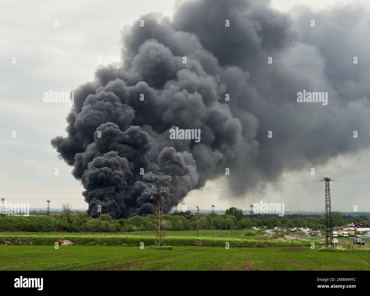 Black toxic smoke from industrial fire burning platic and rubber waste, air pollution by