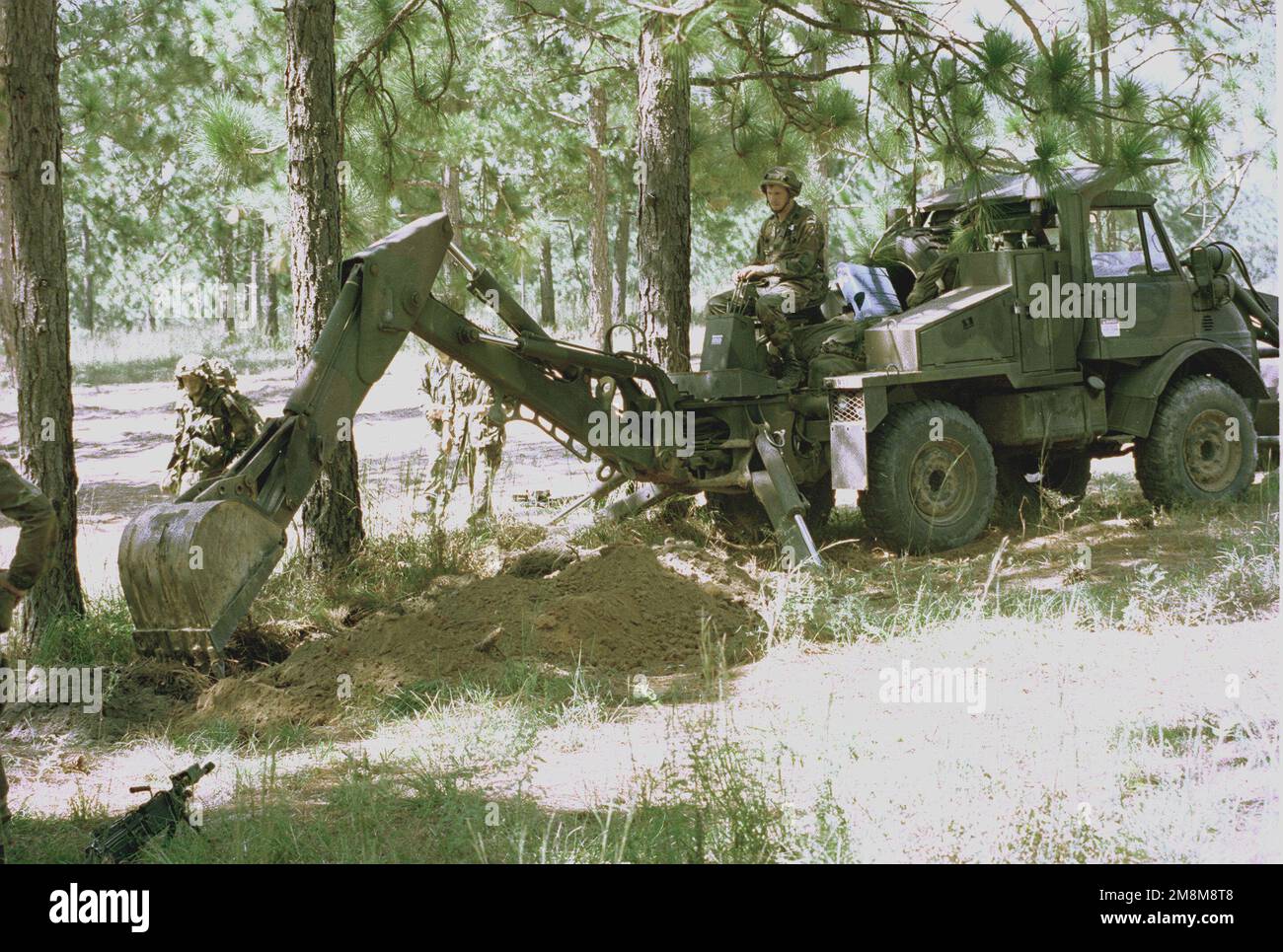 Engineers use a backhoe to help the infantry dig in at the Joint Readiness Training Center. Base: Fort Polk State: Louisiana (LA) Country: United States Of America (USA) Stock Photo