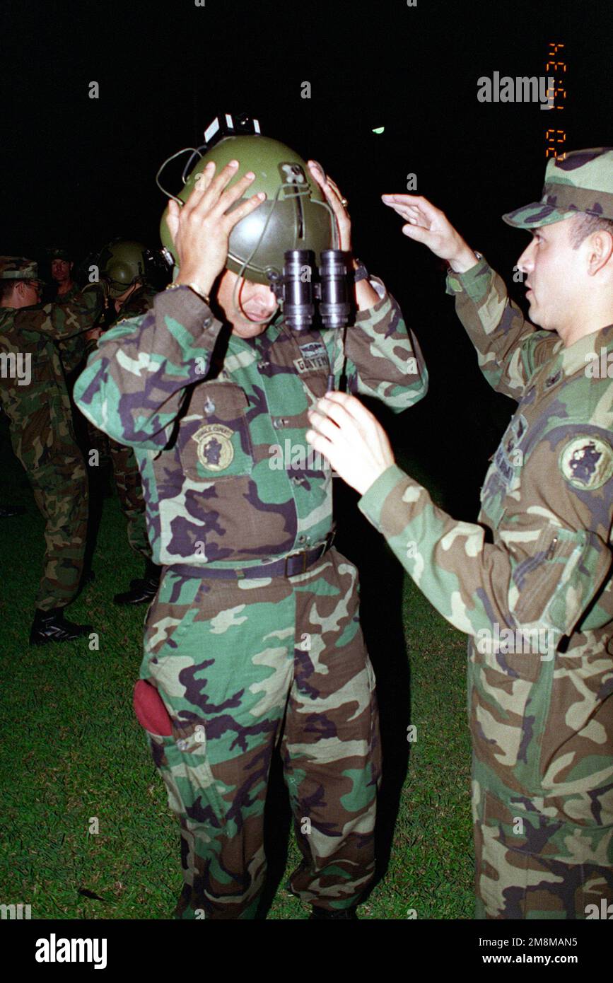 Brigadier General Sergio Arnoldo Camargo Murralles, CHIEF of STAFF, Guatemalan Army gets fitted with night vision equipment (AN/VIS-6), for a later flight, by CHIEF Warrant Officer 3 Montufar. Base: Fort Clayton Country: Panama (PAN) Stock Photo