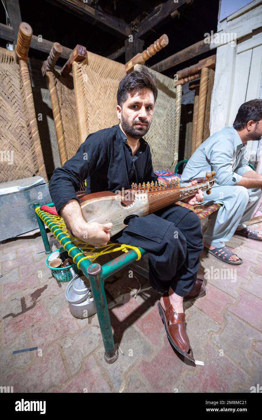 A Pakistani adult man playing a Rubab (stringed musical instrument), Peshawar, Pakistan Stock Photo