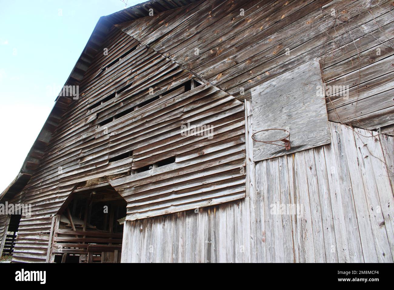 Weathered old barn wall with basketball hoop Stock Photo