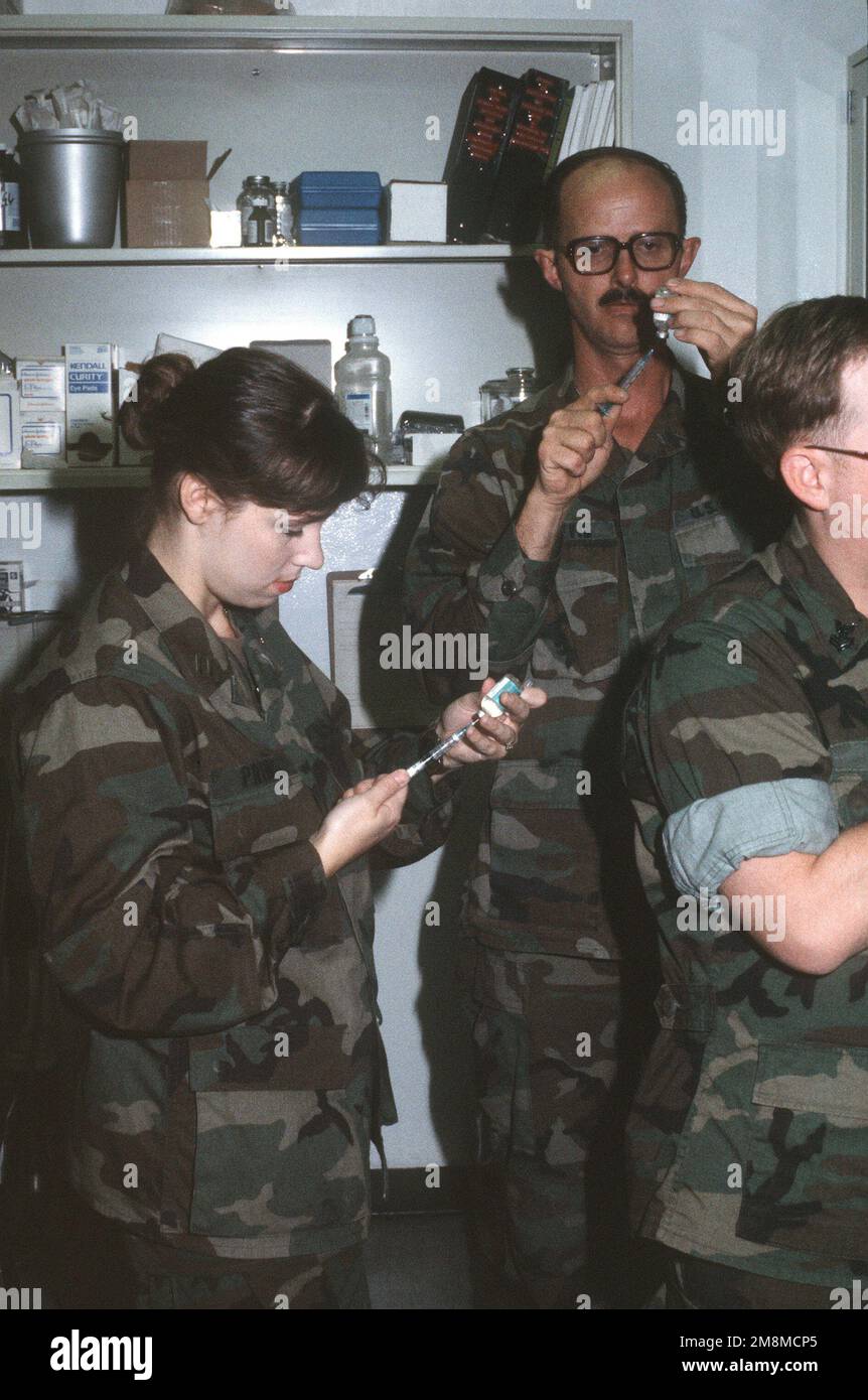 LT. Andrea Prince, medical officer for Naval Mobile Construction Battalion 133 (NMCB-133) and Hospital Corpsman First Class (HM1) Timothy Natvik prepare hepatitis shots for personnel of NMCB-133 detachment being sent into Bosnia. Subject Operation/Series: JOINT ENDEAVOR Base: Camp Mitchell State: Rota Country: Spain (ESP) Stock Photo