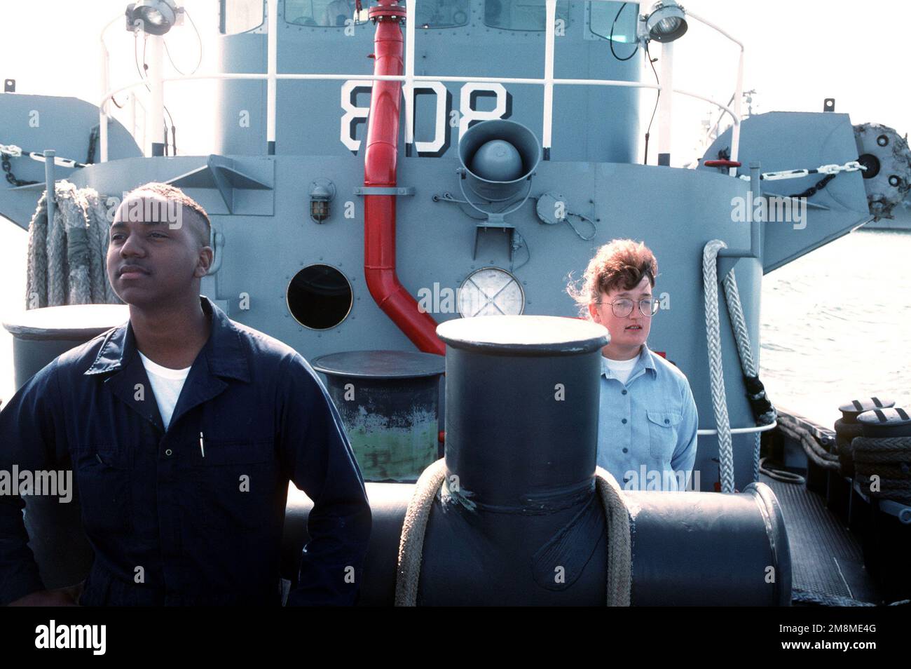 Boatswain Mates, male and female, stand at the ready on the bow of the