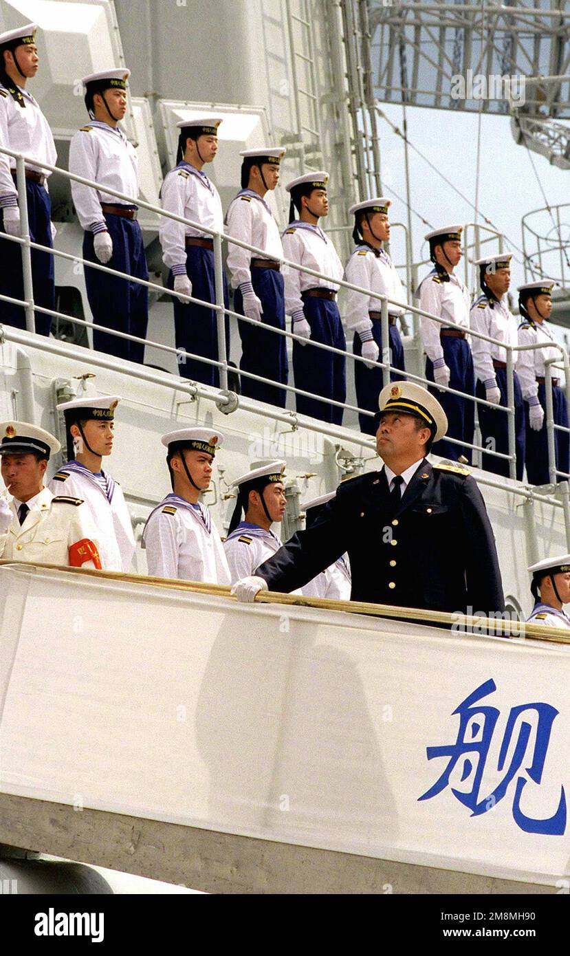 Chinese Admiral Wang Yongguo (Right, foreground) prepares to come ashore during welcoming ceremonies. This marks the first time Chinese warships have crossed the Pacific and visited the Continental United States. The Luhu Class Destroyer HARIBING (DDG 112), Luda II Class Destroyer, ZHUHAI (DDG 166), and a supply ship, the Fusu Class, NANYUN (AOR/AK 953) (Only one of the Chinese Destroyers is shown in this image), stopped at Naval Station, North Island, San Diego, California, on March 21st, 1997. Base: Naval Air Station, North Island State: California (CA) Country: United States Of America (USA Stock Photo