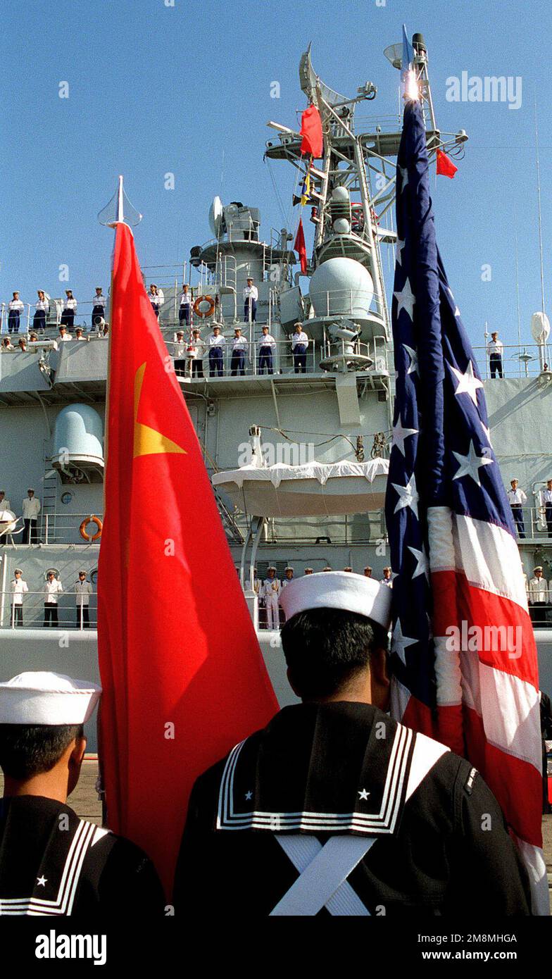 American sailors parade the colors of the United States and China during a ceremony to bid farewell to the departing People's Liberation Army (Navy) vessels. This marks the first time Chinese warships have crossed the Pacific and visited the Continental United States. The Luhu Class Destroyer HARIBING (DDG 112), Luda II Class Destroyer, ZHUHAI (DDG 166), and a supply ship, the Fusu Class, NANYUN (AOR/AK 953) (Chinese vessels not shown), stopped at Naval Station, North Island, San Diego, California. Base: Naval Air Station, North Island State: California (CA) Country: United States Of America ( Stock Photo