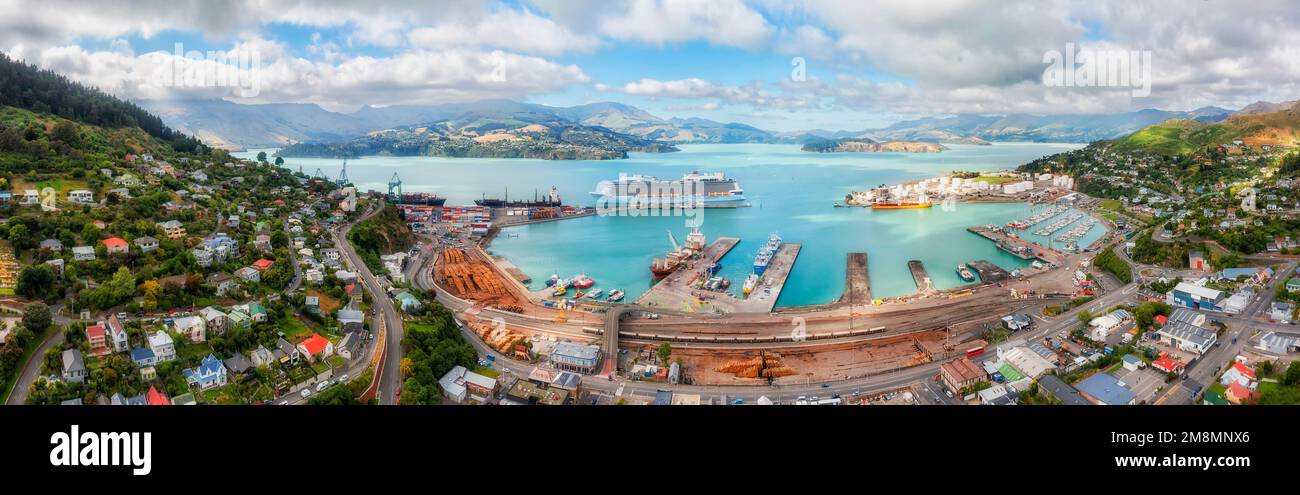 Scenic panorama of Diamond harbour in Lyttleton port town of New zealand with busy cargo terminal and passenger cruise ship at wharf. Stock Photo