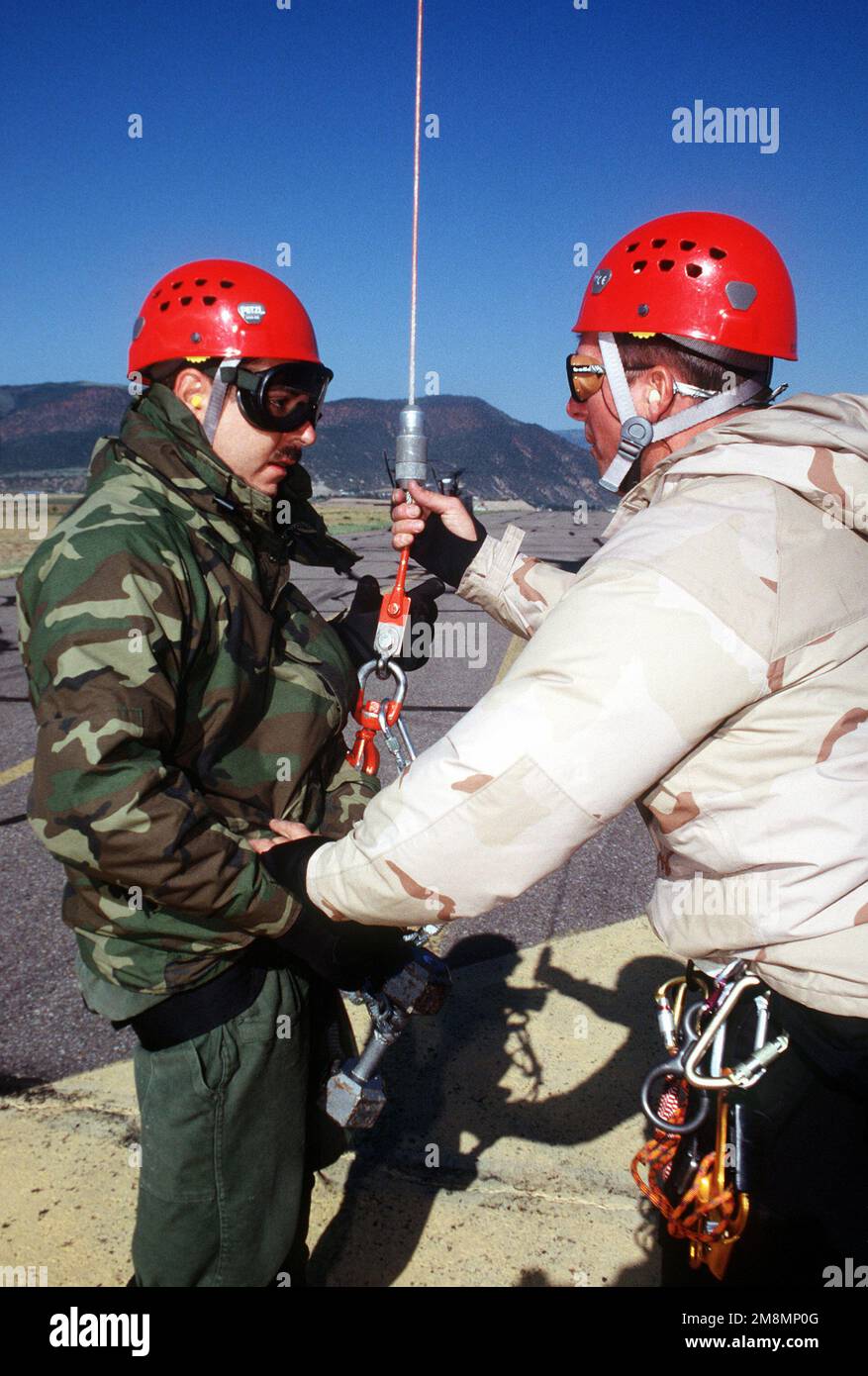 Explosive Ordnance Disposal SPECIALIST SRA Kelly Roy (left) receives some last minute instructions from pararescueman MSGT Rick Weaver (right) prior to being hoisted by a CH-47 helicopter. The training will enable A-10 recovery team members to search in areas inaccessible by foot. Base: Eagle State: Colorado (CO) Country: United States Of America (USA) Stock Photo