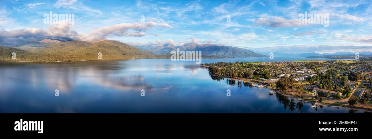 Scenic aerial panorama of Te Anau lake and town in Milford sound fiordland of New Zealand in soft morning sun light. Stock Photo