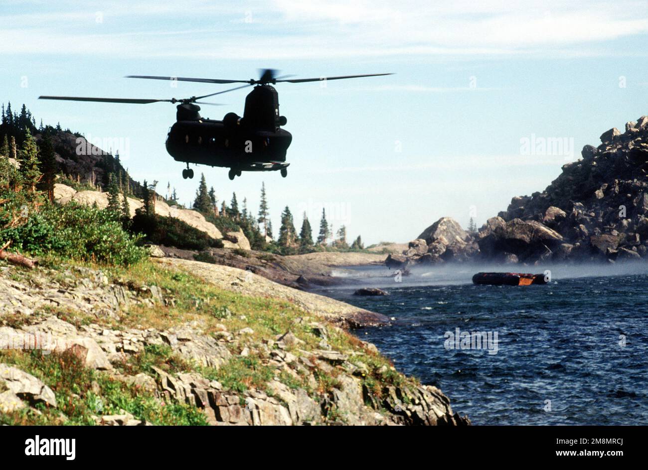 A CH-47 from Detachment 1, Company G, 140th Aviation, Nevada Army National Guard, drops off the Navy's Zodiac boat. The Navy's Explosive Ordnance Disposal Mobile Unit 7 from San Diego, California will search the lake, one of six near the crash site, for remnants of the four 500 pound bombs carried by the A-10 that crashed on Gold Dust Peak. Base: New York Lake State: Colorado (CO) Country: United States Of America (USA) Stock Photo