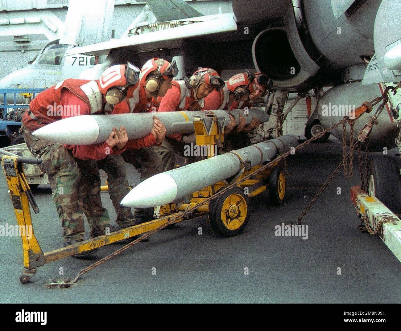 Aviation ordnancemen load an AIM-7 Sparrow III missile onto Aviation ordnancemen load an AIM-7 Sparrow III missile onto