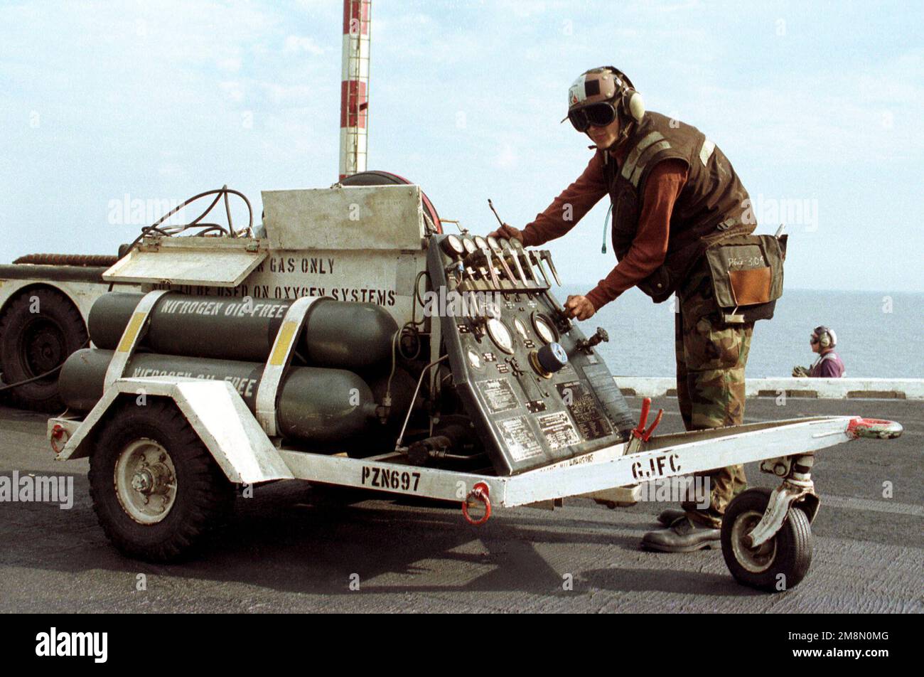 AMN John Plumstead uses compressed air to open the canopy of an aircraft aboard the aircraft