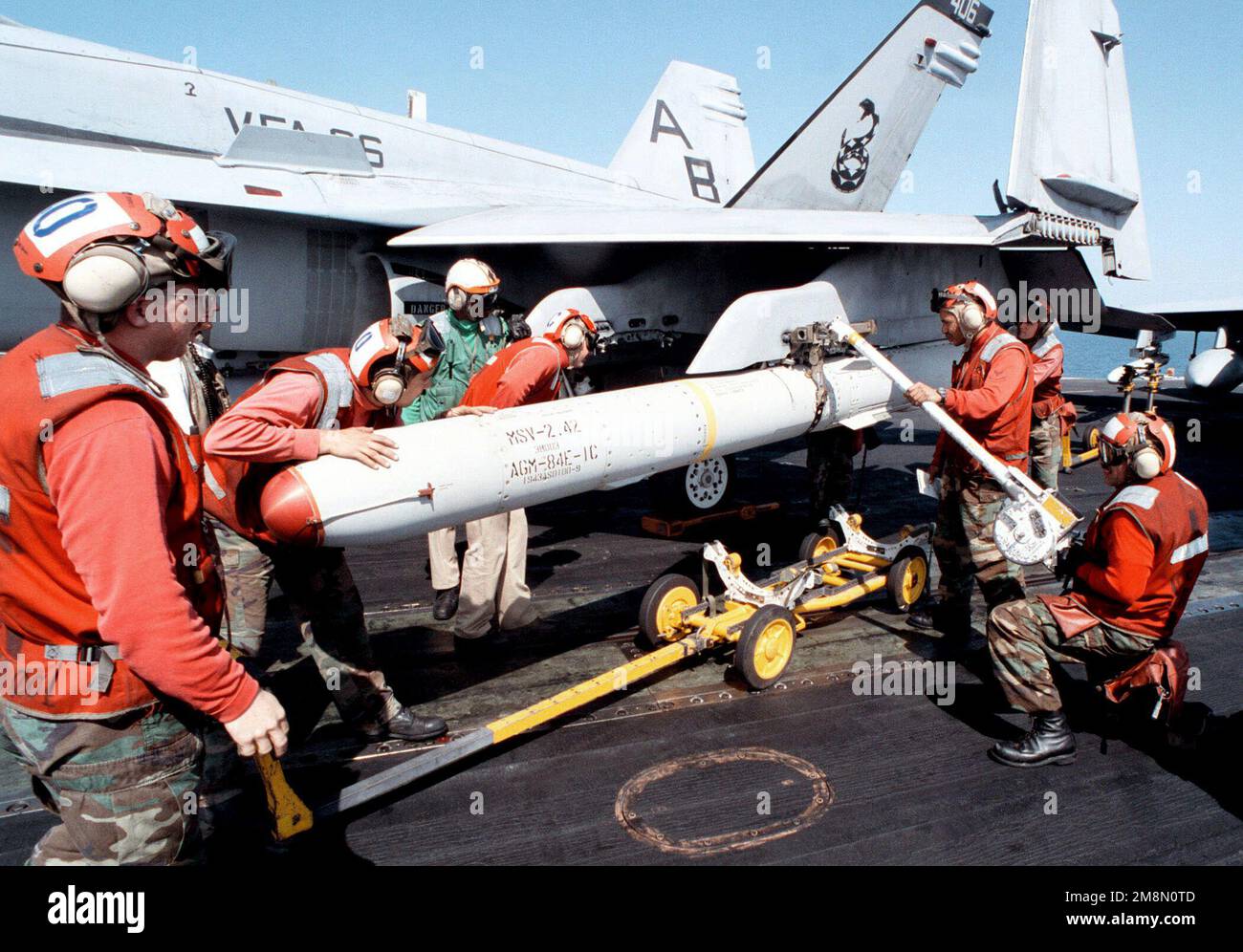 (From left to right) Aviation Ordnanceman David Dorris, Joel Kopp, Keith Collins, and Hector Hernandez load an AGM-84E SLAM Missile onto an F/A-18C Hornet aboard USS GEORGE WASHINGTON (CVN 73). GEORGE WASHINGTON and VFA-86 are deployed to the Persian Gulf in support of Operation Southern Watch. Subject Operation/Series: SOUTHERN WATCH Base: USS George Washington (CVN 73) Country: At Sea Stock Photo