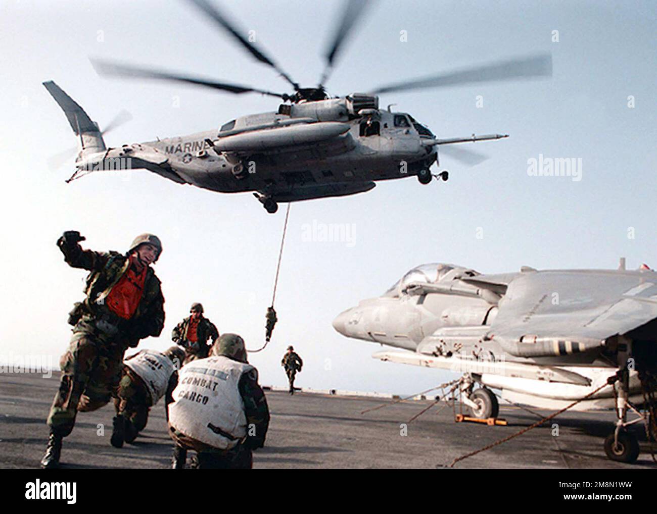 Infantry men from the 26th US Marine Expeditionay Unit (MEU) practice 'fast roping' from a CH-53 'Super Stallion' aboard the Wasp Class Amphibious Assault Ship, USS WASP (LHD 1). A US Navy EA-6B Prowler is partially seen at the right. The WASP and 26th MEU are en route to the Mediterranean on a scheduled six-month deployment. Base: USS Wasp (LHD 1) Country: Mediterranean Sea (MED) Stock Photo
