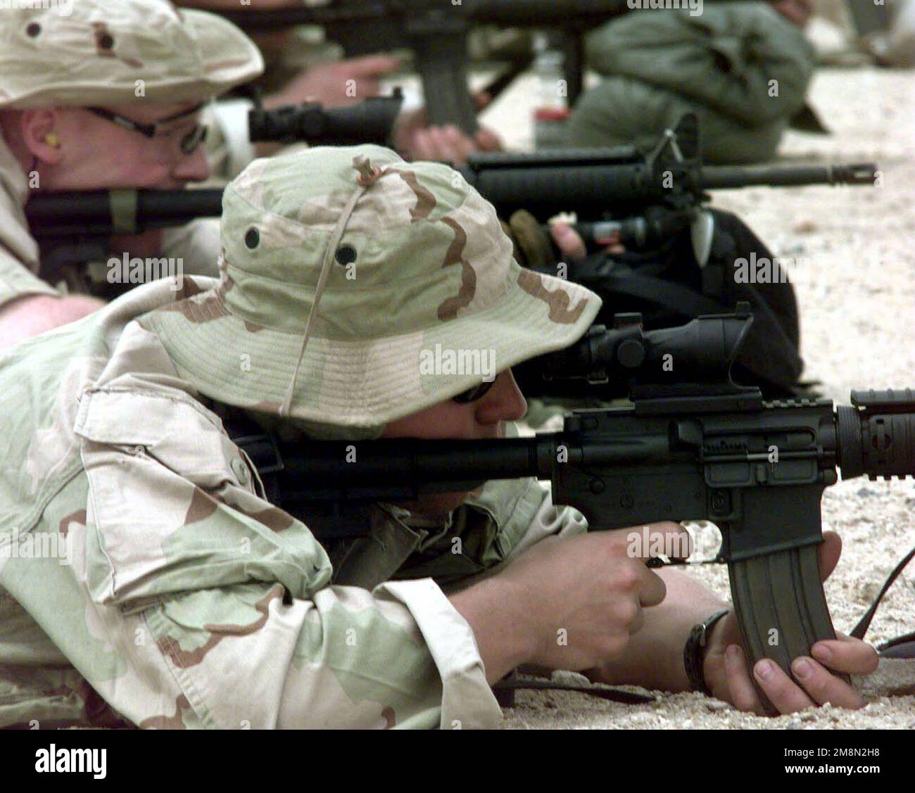 A US Navy SEALS, from SEAL team 8, shoot M4 Carbine rifles on a firing range in Kuwait as part