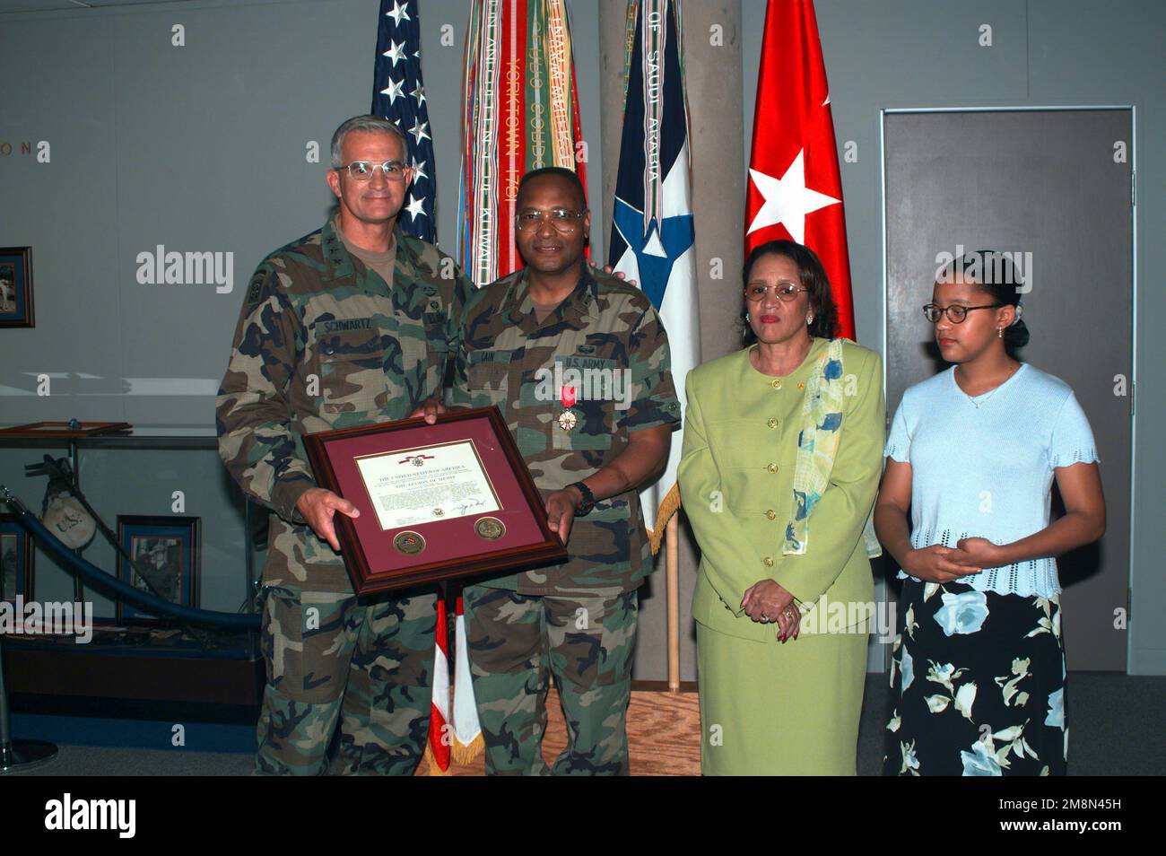 LTG Thomas A. Schwartz (left), Commanding General of III Corps and Fort Hood pose with COL Eddie Cain after presenting the colonel with the Legion of Merit medal and citation for his exceptionally meritorious service while assigned as chemical officer, III Corps and Fort Hood. Looking on are the colonel's wife Fredia (second from right) and his daughter Trina (right). Base: Fort Hood State: Texas (TX) Country: United States Of America (USA) Stock Photo