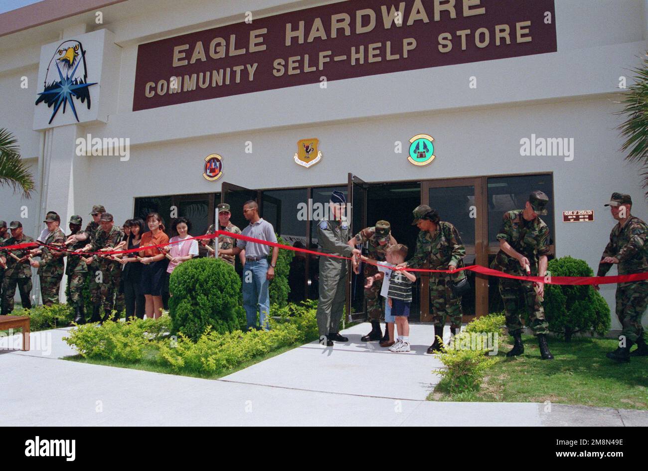 The ribbon cutting ceremony marks the grand opening of Eagle Hardware, a new concept in self-help in the Air Force at Kadena Air Base. On May 22, 1998, Brigadier General John R. Baker, Commander 18th Wing, CHIEF MASTER Sergeant Robert Stivers, SENIOR Enlisted Advisor, and members of the 18th Civil Engineering Squadron, with a little help officially open the store. Base: Kadena Air Base State: Okinawa Country: Japan (JPN) Stock Photo