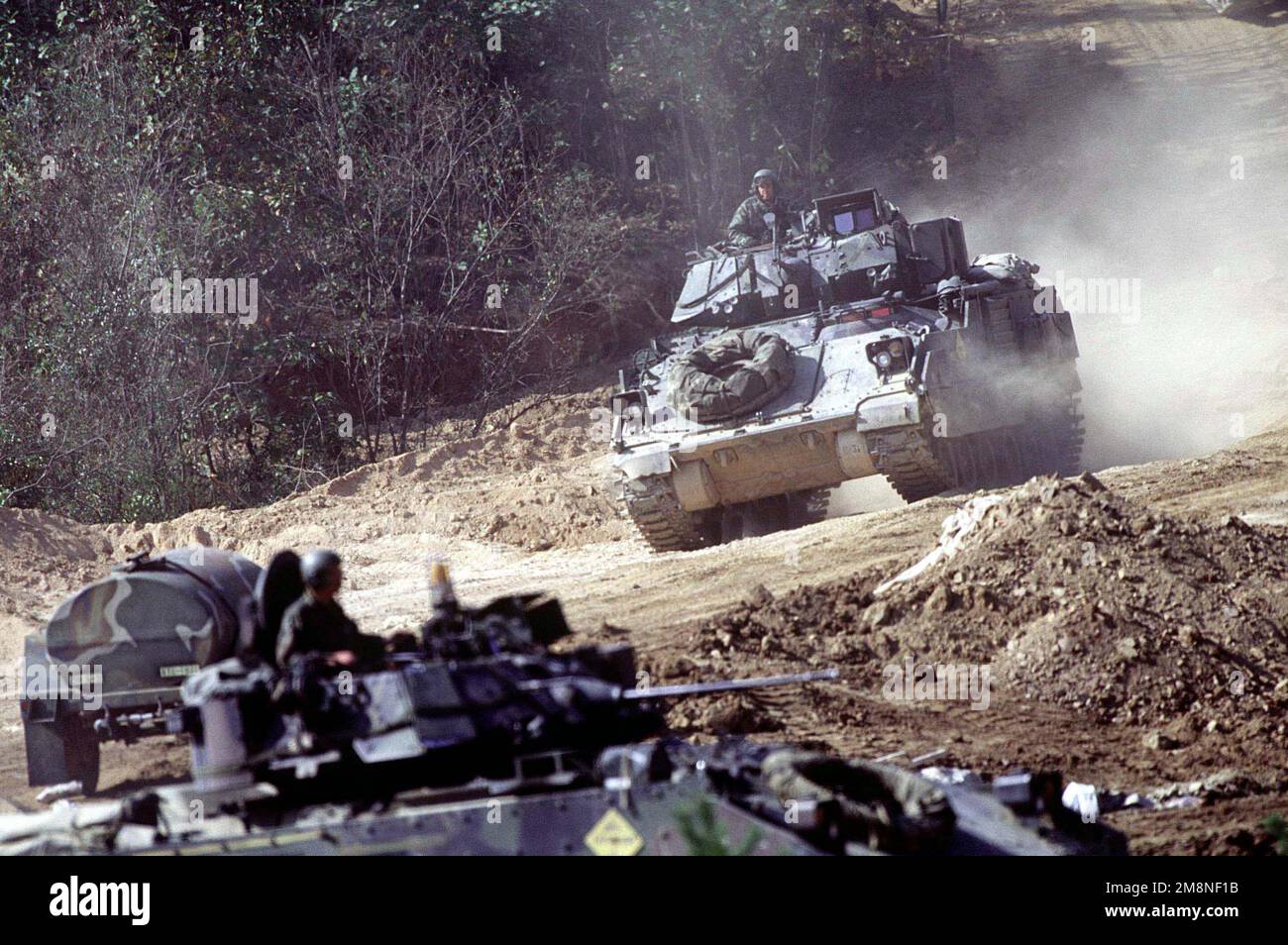 Several US Army M2/A2 Bradley Fighting vehicles, assigned to C Troop of the 4th Squadron, 7th Cavalry Regiment drive to the live fire range for gunnery training at the Korea Training Center, Republic of Korea on Oct. 25, 1998. The center is manned throughout the year and various armored units rotate through training scenarios to meet yearly live gunnery training requirements. Subject Operation/Series: KOREA CD Base: Korea Training Center Country: Republic Of Korea (KOR) Stock Photo