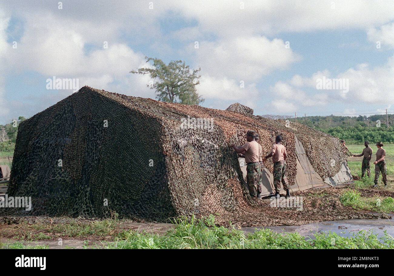US Army (USA) Soldiers set up Camouflaged nets over living facility tents at North Field, on the Island of Tinian, during Exercise TANDEM TRHUST 99. Subject Operation/Series: TANDEM THRUST 99 Base: North Field, Tinian Island Country: Northern Mariana Islands (MNP) Stock Photo